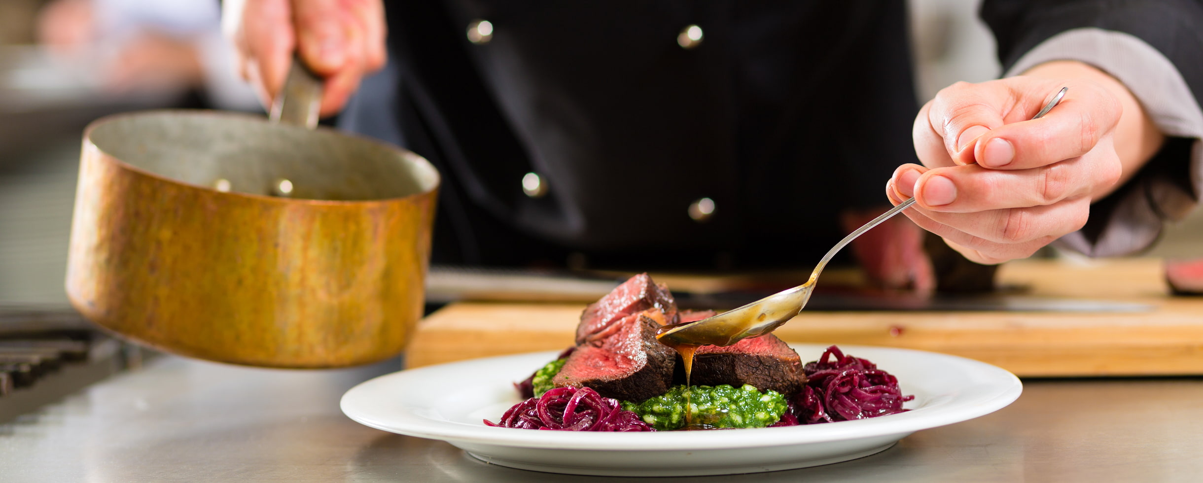 Chef plating steak dinner plate