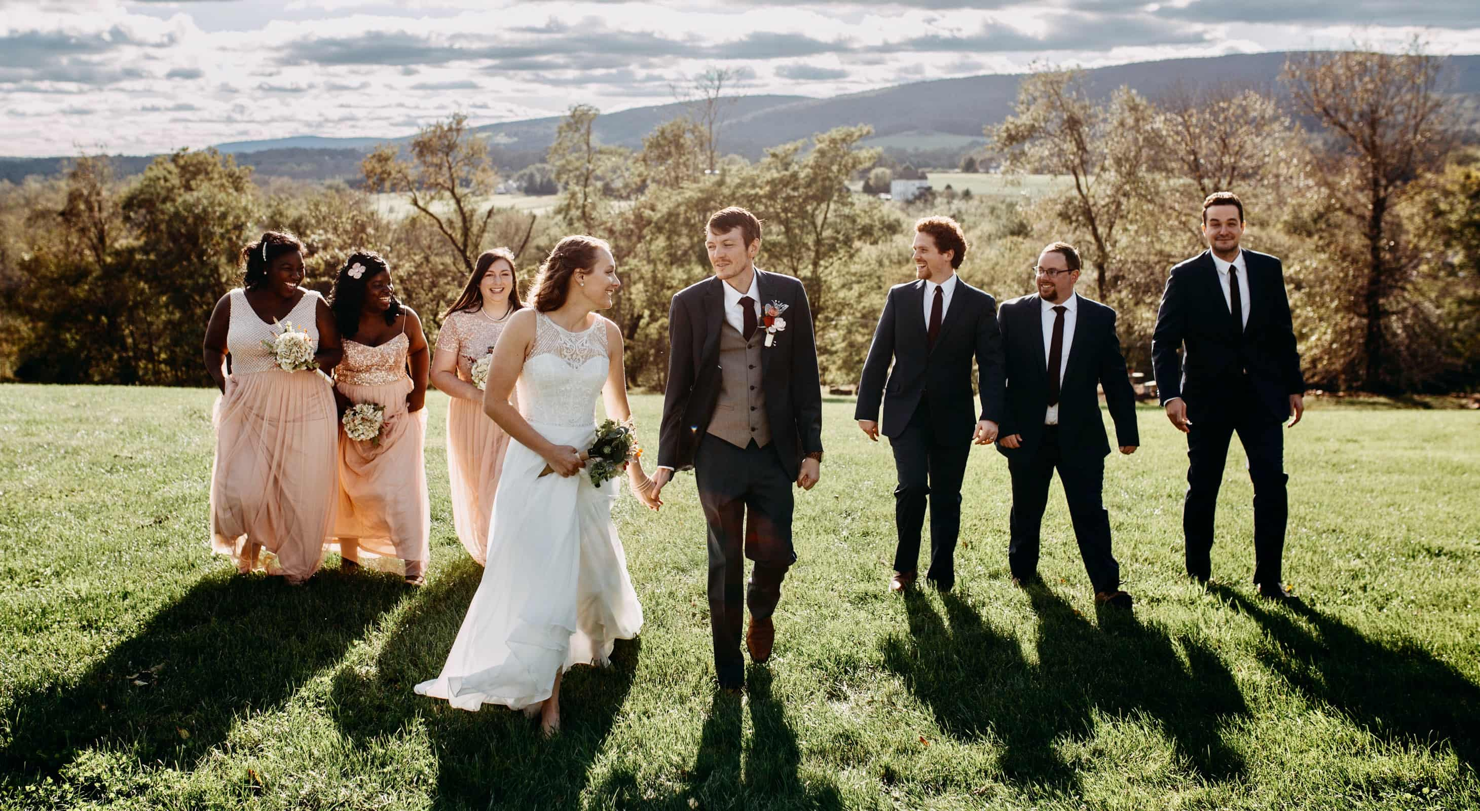 Wedding party walking through a field at our Northern Virginia elopement venue