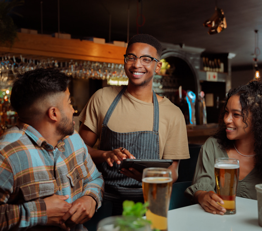 Restaurant customers talking with friendly server