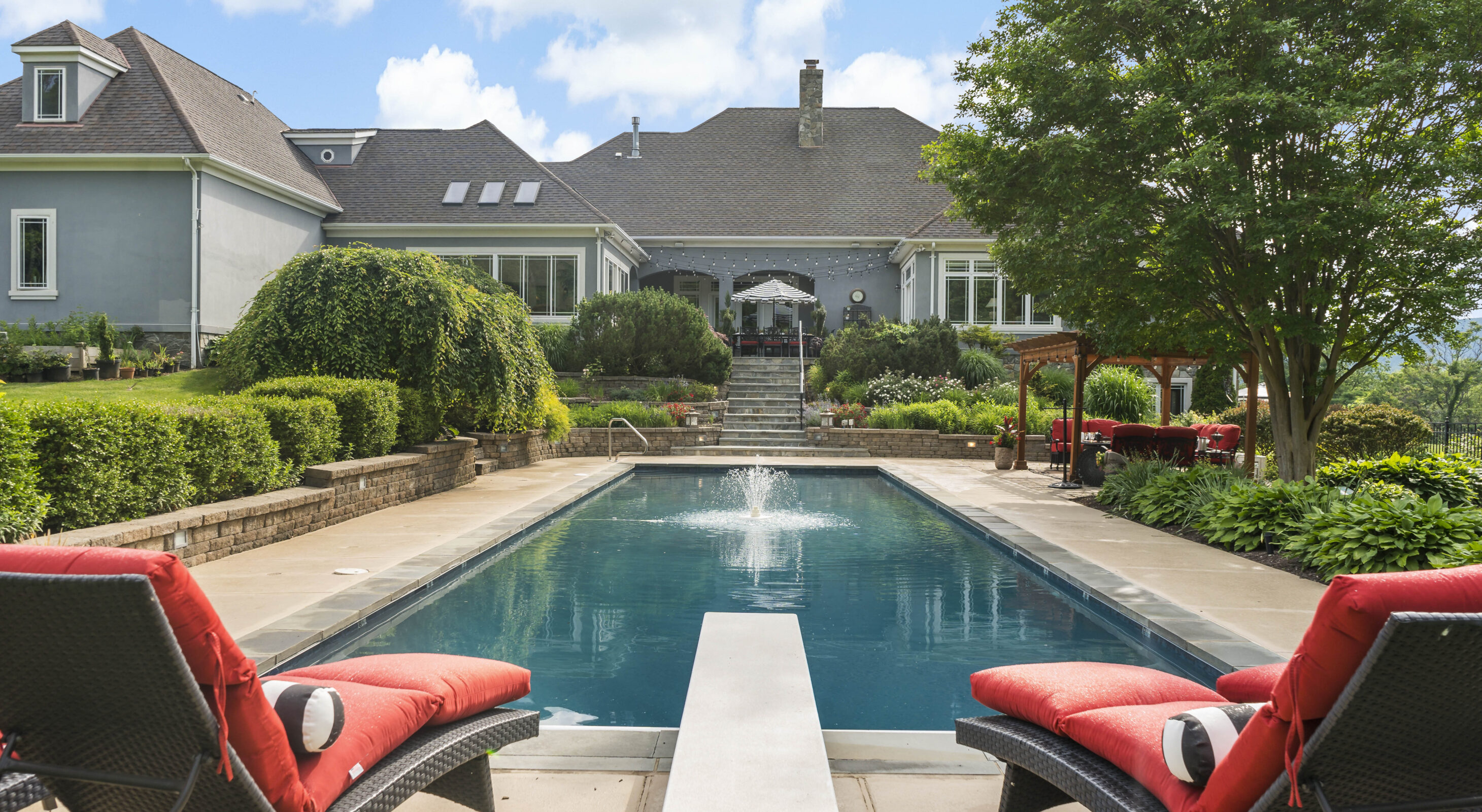 Seating area with comfortable red cushions by the pool at our Northern Virginia bed & breakfast